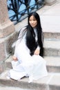 Asian girl sitting on stone embankment Royalty Free Stock Photo
