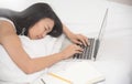 Asian girl sleeping with laptop on her bed. Royalty Free Stock Photo