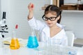 Asian girl, small, sitting in science room, studying in science class, practical class, He was squeezing water from the flask,