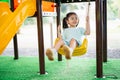 Asian girl smile play swing on school or kindergarten yard or playground. Healthy summer activity for children. Little asian girl Royalty Free Stock Photo