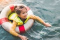 Asian girl smiling in her holiday and holding life buoy near in water Royalty Free Stock Photo