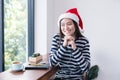 Asian girl smiling sitting in coffee shop,Woman wearing Santa Cl Royalty Free Stock Photo