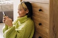 Asian girl smiling and using mobile phone while sitting on floor Royalty Free Stock Photo