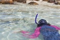 Asian girl snorkels while heading to shore