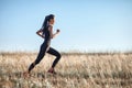 Asian girl in sportswear running across field, morning workout Royalty Free Stock Photo