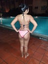 asian girl standing poolside after evening swim
