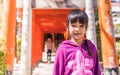 An Asian girl standing under Tori Entrance of Sumiyoshi Shrine.