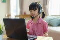 Asian girl student video conference e-learning with teacher and classmates on computer in living room at home. Homeschooling and Royalty Free Stock Photo