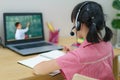 Asian girl student video conference e-learning with teacher and classmates on computer in living room at home. Homeschooling and Royalty Free Stock Photo