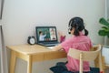 Asian girl student video conference e-learning with teacher and classmates on computer in living room at home. Homeschooling and Royalty Free Stock Photo