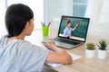 Asian girl student video conference e-learning with teacher on computer in living room at home. Homeschooling and distance Royalty Free Stock Photo