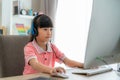 Asian girl student video conference e-learning with teacher on computer in living room at home. Homeschooling and distance Royalty Free Stock Photo