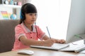 Asian girl student video conference e-learning with teacher on computer in living room at home. Homeschooling and distance Royalty Free Stock Photo