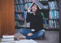 Asian girl students reading books and using notebook in the library Royalty Free Stock Photo