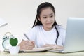 Asian girl is studying online via the internet with a cheerful smile, stay home Royalty Free Stock Photo