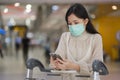 Asian girl with surgical mask check flight by smartphone in airport, New normal lifestyle, Covid-19 crisis, travel bubble
