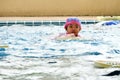 Girl swimming in swimming pool catching yellow foam pad in pool
