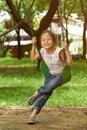 Asian girl on a swing playing at a park