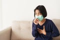 Asian girl symptom cough and are protective with medical mask while sitting on sofa, Asia child wearing a protection mask epidemic Royalty Free Stock Photo