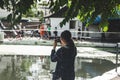 Asian girl is taking a photo near Paddington Canal in Little Venice, London
