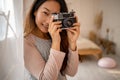 Asian woma taking pictures with old film camera. woman Photographer making pictures with retro camera having fun at home. Royalty Free Stock Photo