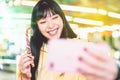 Asian girl taking selfie with mobile phone in amusement park - Happy woman having fun with new trends smartphone apps Royalty Free Stock Photo