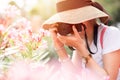 Asian girl teen tourist taking a nature photo travel while walking with hat and backpack bag Royalty Free Stock Photo