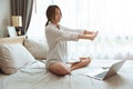 Asian girl teen wake up at the morning stretching working online at home with laptop computer Royalty Free Stock Photo