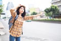 Asian girl tourists Standing on the roadside To wave a taxi for travel in the capital Royalty Free Stock Photo