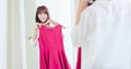 Asian girl trying dress happily Royalty Free Stock Photo