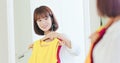 Asian girl trying dress happily Royalty Free Stock Photo