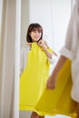 Asian girl trying dress happily Royalty Free Stock Photo