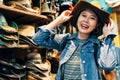 Asian girl trying trilby in the cowboy shop