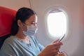 Asian girl use a protection mask for coronavirus or covid 19 in airplane.