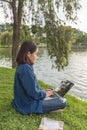 Asian girl using laptop and sitting on grass Royalty Free Stock Photo