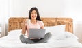 Asian Girl Using Laptop Watching Movie Sitting On Bed Indoors Royalty Free Stock Photo