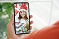 Asian girl video call for greeting in Christmas celebration, Hand holding mobile phone while talking with asia female in