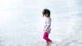 Asian girl walks in sea by the beach. Children play with nature and sand. Child are happy in the summer. Royalty Free Stock Photo