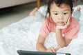 Asian girl are watching video that are exciting on online media. The little girl use the tablet to watch video for home