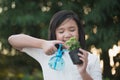 Asian girl watering a red flower in the garden Royalty Free Stock Photo