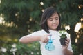 Asian girl watering a red flower in the garden Royalty Free Stock Photo