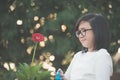 Asian girl watering a red gerbera Royalty Free Stock Photo