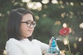 Asian girl watering a red gerbera Royalty Free Stock Photo