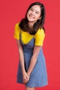 Asian girl Wear yellow shirt and short skirt pose in advertising and presenting goods and contents gesture with friendly smile Royalty Free Stock Photo