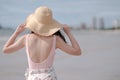 Asian girl wearing pink bodysuit and straw hat on the beach