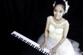 An Asian girl wearing a white evening dress for the piano performance