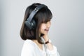 Asian girl in white casual dress listening to music from black headphones. In a comfortable and good mood. Royalty Free Stock Photo