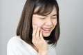 Asian girl in white casual dress Show off the toothache, Maybe because of not maintaining good oral health.