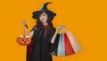 Asian girl in witch costume holding jack o lantern and shopping sale bag for halloween party trick or treat concept isolate on Royalty Free Stock Photo