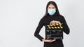 Asian Girl or woman wear face mask and hand`s holding black clapper board or movie slate use in video production ,film, cinema Royalty Free Stock Photo
